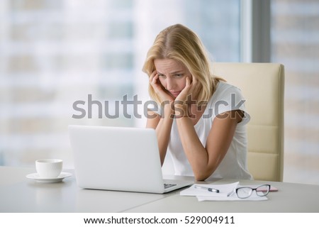 Portrait of young bored attractive woman at office desk, with laptop, feeling hopeless, lost motivation and inspiration for project, unwilling to learn,