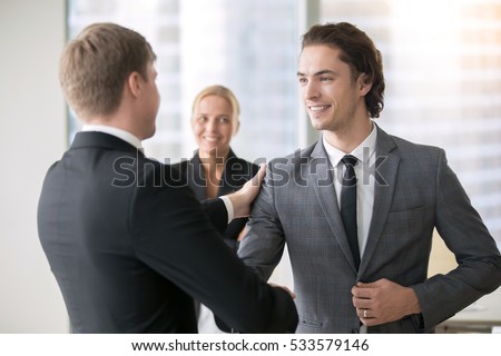 Boss promoting male subordinate. Two businessmen handshaking, congratulating on promotion, hired young consultant, promising innovation, ready for new heights, getting higher pay rate, financial bonus