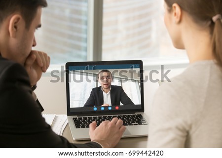 Employees participate virtual conference with boss running business remotely, businesspeople hold online meeting on laptop group chat, entrepreneurs making video call to partner, close up rear view