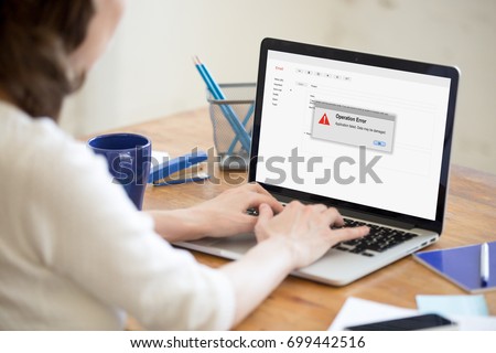 Woman having problem with laptop while using online email app, application failed warning, broken computer crash, operation error, pc failure message, data loss, focus on screen, close up rear view