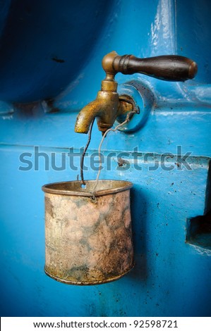 Old tap with rusty mug - water supply shortage