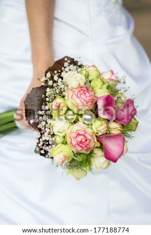 Bride holding a bouquet of purple callas