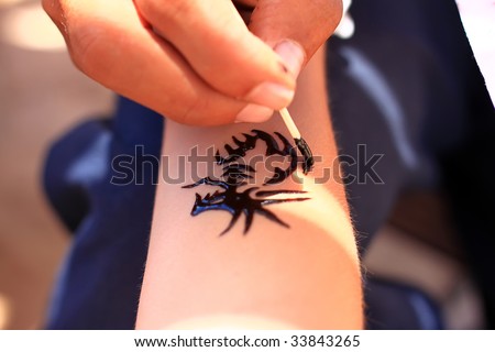 stock photo A man making temporary henna tattoo