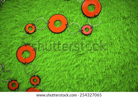 orange beads on a green knitted cloth