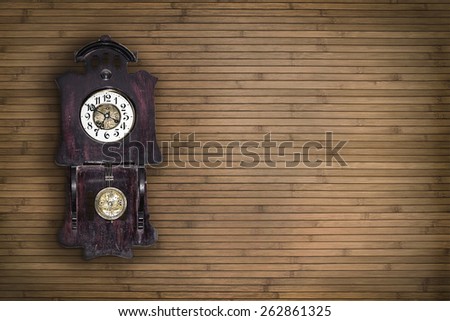 old pendulum clock on the background of wooden wall