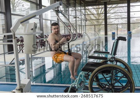 Disabled man in a swimming pool. Wheelchair. Disabled person in a wheelchair.
