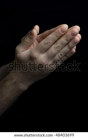 Male hands, folded in prayer.