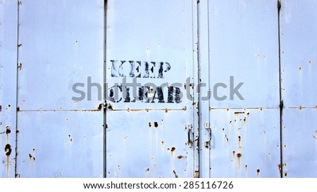 Keep Clear sigh on rusty metal door