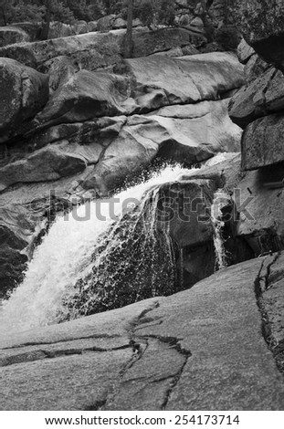 A black and white landscape photograph of waterfall streaming down rocks in Yosemite National Park Ã¢Â?Â? taken while hiking Vernal Falls.