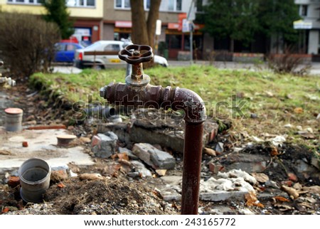 Old and dirty water pipes and tap after building demolition