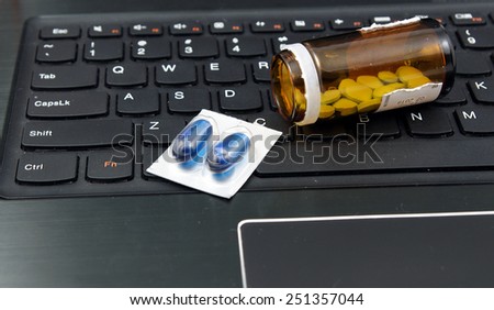 Medicines and pills on the laptop, notebook keyboard. Stress in the work, Anti virus