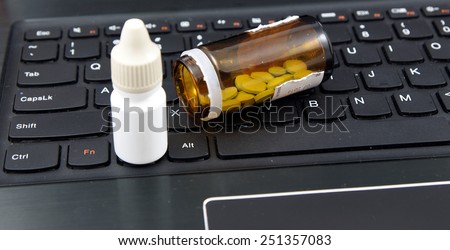 Anti virus (antivirus) set including pills and medicines on the laptop keyboard. There are no trademarks on the image both on the medicines and keyboard.