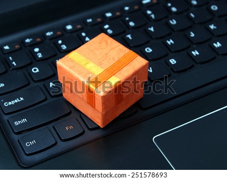 Web shopping / Internet shopping - orange gift box on the black laptop keyboard