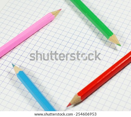 Colorful crayons on the notebook grid background (focus on small part of the image only - intentionally)