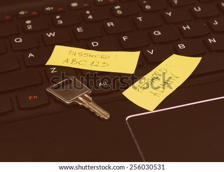 Weak, easy and insecure password typed on post it notes together with the security key on the laptop keyboard - classic style