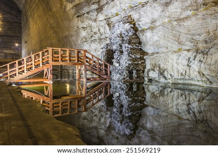 Wooden bridge reflexion in underground salt mine lake