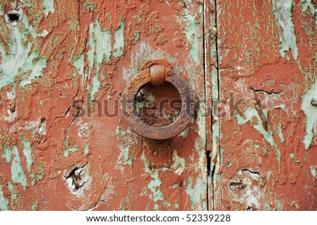 old rusty knocker on damaged antique door