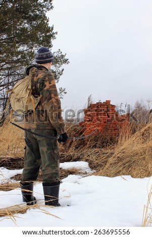 DONETSK, UKRAINE - March 8, 2015: pro-Russian separatist with a bow standing near destroyed house with a red brick oven