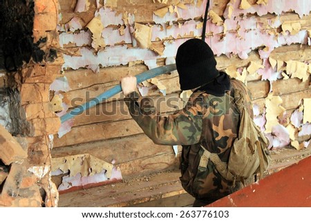 DONETSK, UKRAINE - MARCH 8, 2015: partisan is breaking furniture in former Ukrainian Army general office in Nizy village