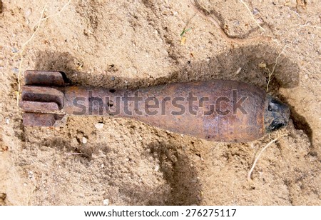 Rusty mortar shell on sand