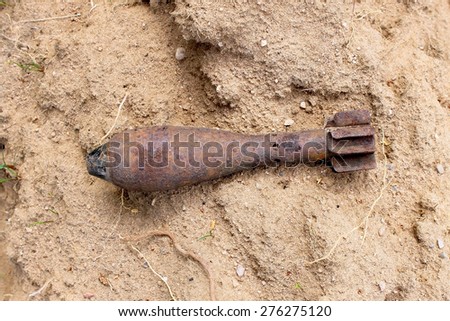 Rusty mortar shell on sand