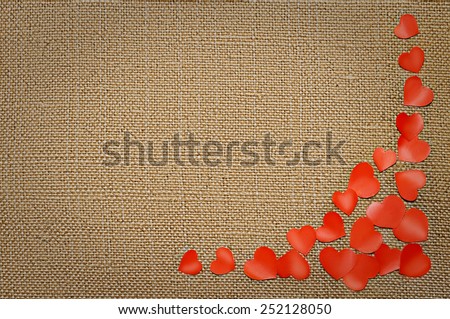 Valentine\'s day card with red hearts on fabric sack texture background