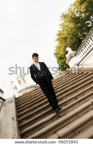 Young man in dark suit on stairs