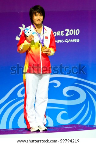 SINGAPORE - AUG. 23: Toa Payoh Pool. Jiao Liu on the podium posing with the gold medal on Aug. 23, 2010 in Singapore. Inaugural Youth Olympic Games Aug. 14-26, 2010, 3m springboard.