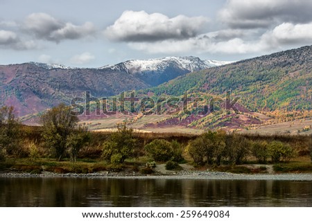 View of the wooded colored mountains and river in the fall
