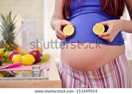 pregnant woman holding lemons