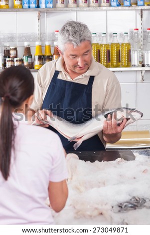 Woman buying a pink salmon