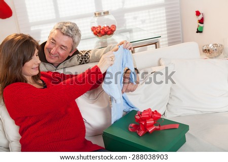 Pregnant opening gift with hes husband in christmas