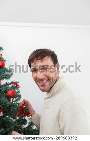 Happy man decorating the chrismas tree
