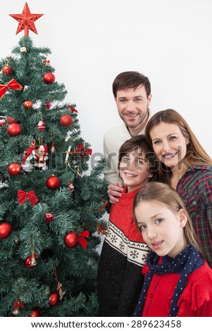 Happy family smiling beside the christmas tree