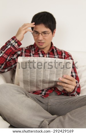 Man reading the newspaper and worried about the news