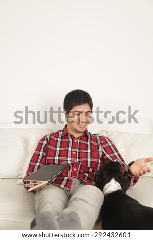 Man reading a book and  petting a dog