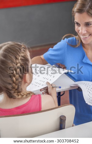 Teacher giving the exam for girl
