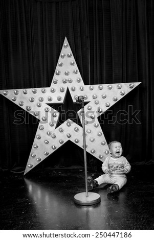 black and white, little girl crying in the background stars and microphone