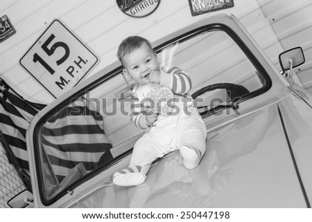 funny little baby sitting on the hood of the car,