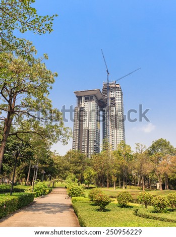 BANGKOK - FEB ,9 : The high building in construction in town near the park . Now The life style of people in town want the green area for relax. THAILAND FEB , 9 2015