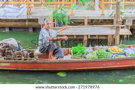 BANGKOK - APRIL,23 : The old man sit on his boat of fruits at floating market. This place is well known for shopping .