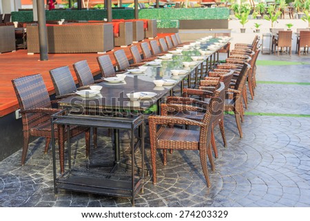 long wood tables and chairs are arranged in outdoor for dinner