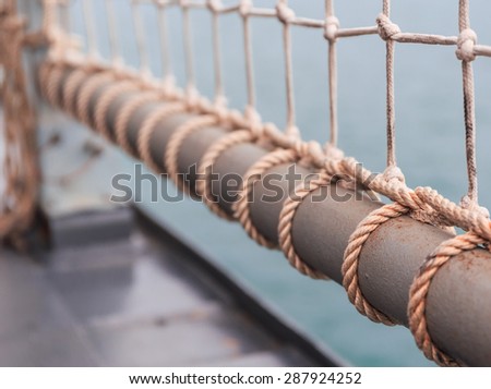 rope net tied iron pole on board ship in nature background