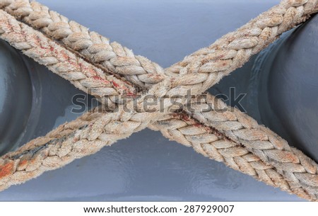 rope  tied mooring cross on board ship in close up