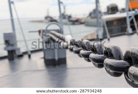 big iron chain of anchor on board navy ship in close up