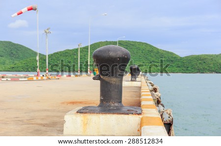 black big mooring stand in line on the port nature background