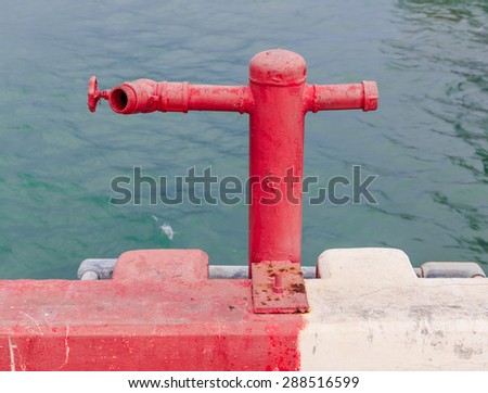 red old water pump on the port in nature backround