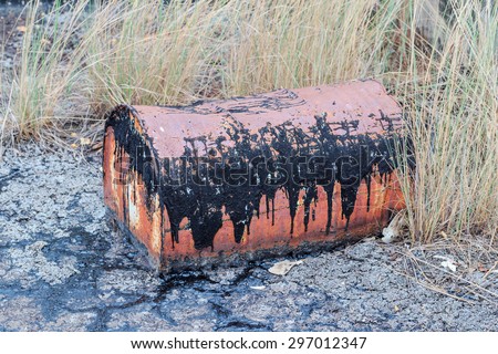 old rusty iron drum barrel with black oil in nature