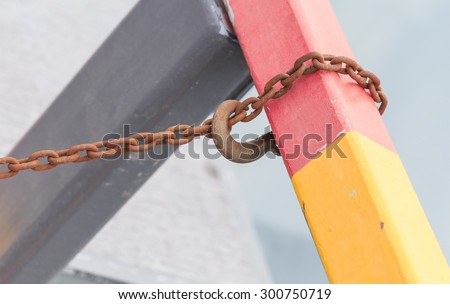 rusty hook and rusty chain connect the colorful pole