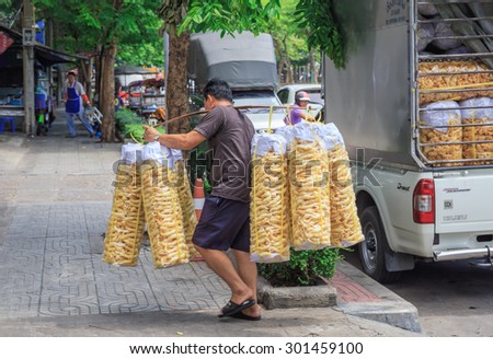 BANGKOK - JULY,30 : The worker carries the pack of fish maw from the truck to the restaurant.This is raw material for delicious Chinese style food. THAILAND JULY,30 2015